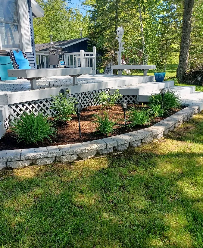 Beautiful backyard garden bed in Grand Rapids maintained by expert landscaping company, with lush lawn care, pest control, and regular lawn mowing services to boost curb appeal.